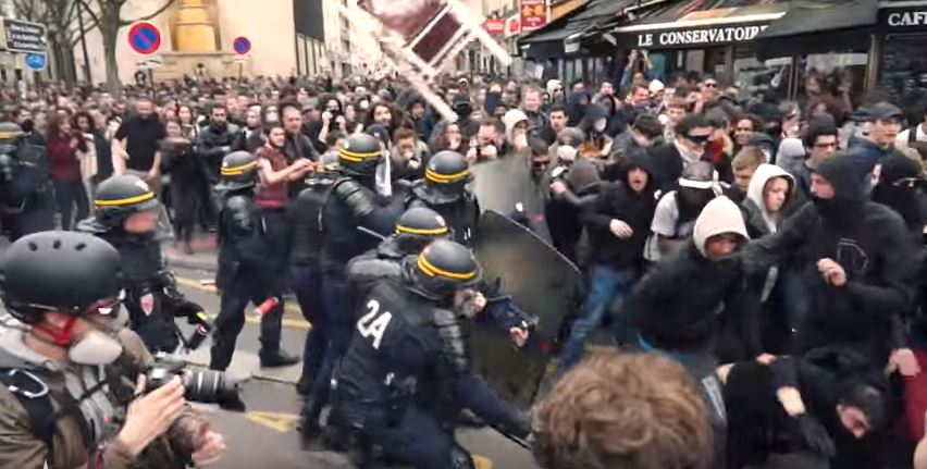 On the same day migrants war in Paris, violent socialists hurl chair at riot police. (YouTube screenshot)