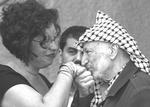 Palestinian leader Yasser Arafat kisses the hand of an unidentified member of a delegation of representatives of international communist organizations that visited him at his headquarters in the West Bank city of Ramallah, Sunday Oct. 13, 2002. (AP Photo/Vadim Ghirda)